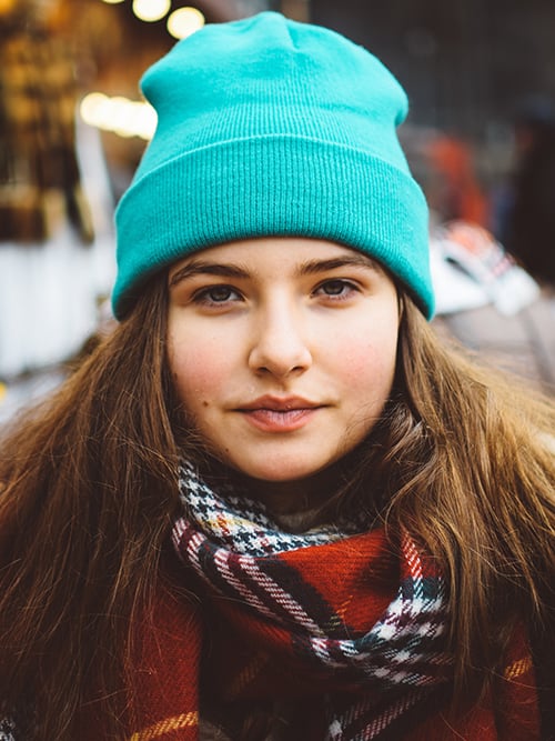 A woman wearing a blue hat and scarf.